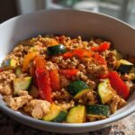 A bowl of High-Protein Heart-Healthy Dinner featuring ground meat, red and yellow bell peppers, and zucchini.