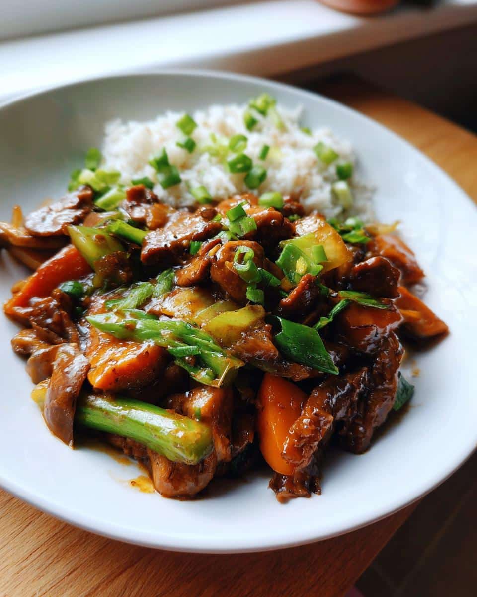 A plate of stir-fried beef and vegetables with white rice, garnished with green onions, a Healthy Balanced Two Weeks Of Easy Dinner Recipes For Two-Homemade Mastery.